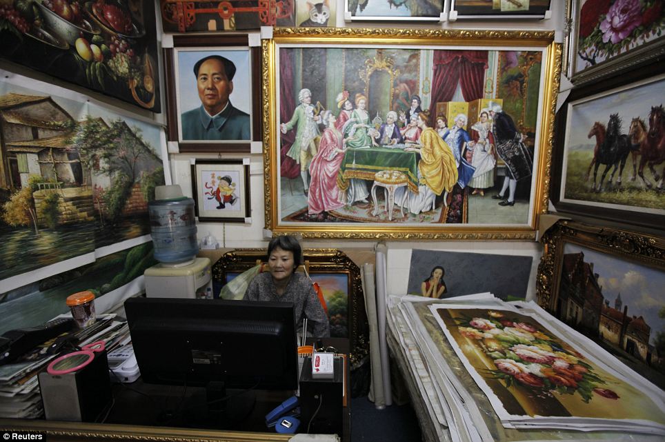 A vendor waits for customers in a gallery: The Dafen district is believed to be the largest mass producer of oil paintings in the world