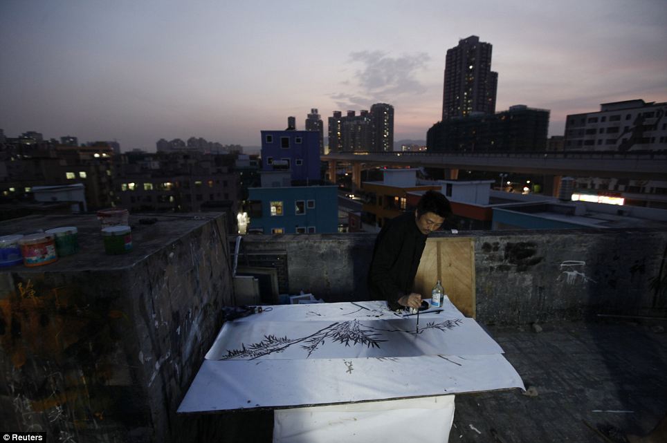 Zhang Wanping works on a Chinese painting on the roof of a studio: Now many of the districts artists have had to adapt their work to cater to newly affluent Chinese customers