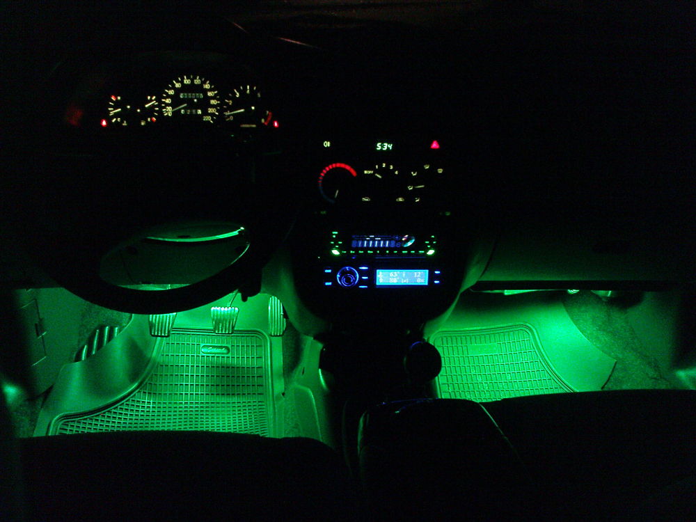 Салон автомобиля с зеленой подсветкой ног